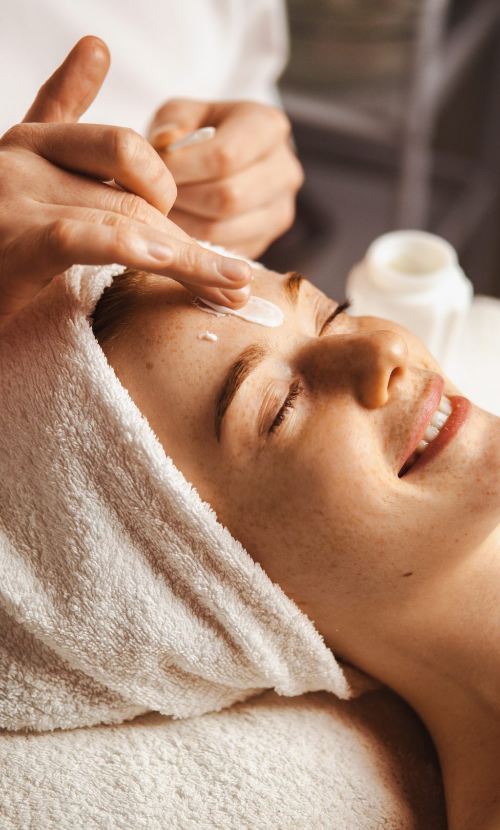 Close-up portrait of woman getting spa facial massage treatment with moisturising cream at beauty spa salon. Natural skin care cosmetic. Health care, beauty treatment. Facial beauty. Woman beauty face.